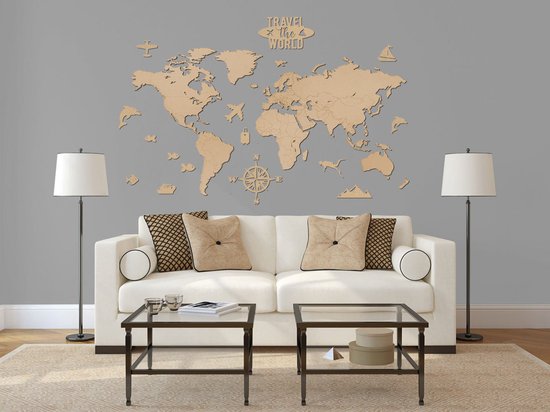 Carte du monde en bois sur un mur gris, au-dessus d'un canapé blanc. La carte comporte de petites figurines.
