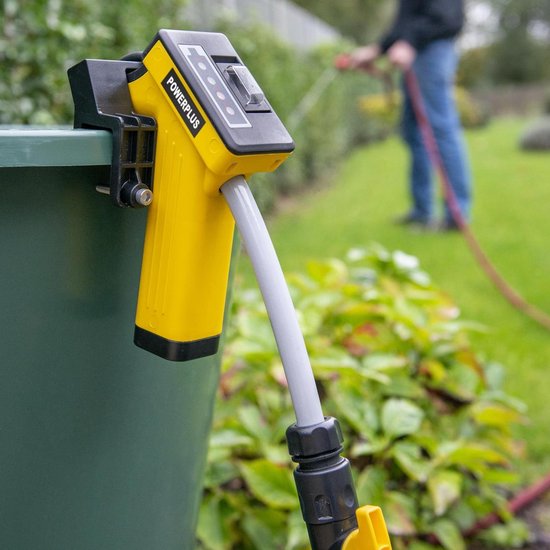 Gele Powerplus pomp met grijze slang en zwarte connector, bevestigd aan een groene bak. Op de achtergrond een tuin.