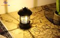 Lanterne de camping noire sur une table avec un motif de carte du monde, lumière LED vive.