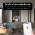 Man in woonkamer houdt iPhone vast met 'Find My' app. Geluid afspelen om tracker te vinden.