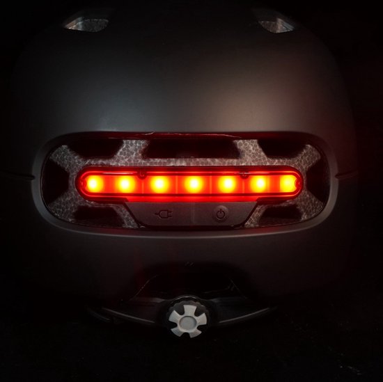 Achterkant van een zwarte LIVALL helm met een rij rode LED's en oplaadpoort.