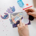 Un enfant colle un autocollant sur un magnet Stitch diamond painting. Le magnet se déroule dans l'espace, avec Stitch surfant sur une planche.