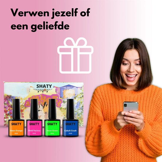 Vrolijke vrouw kijkt naar haar telefoon, naast een geschenkdoos met SHATY nagellak flessen.