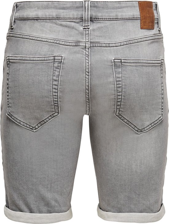 Achterkant van grijze denim shorts met omgeslagen broekspijpen.