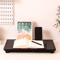 Zwart bedtafeltje met opgevouwen poten, met een tablet, boek, pen en telefoon.