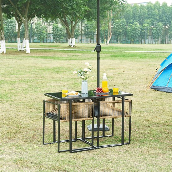 Een tuinset met een vierkante glazen tafel, twee stoelen met gevlochten touw en een parasol in een tuin.