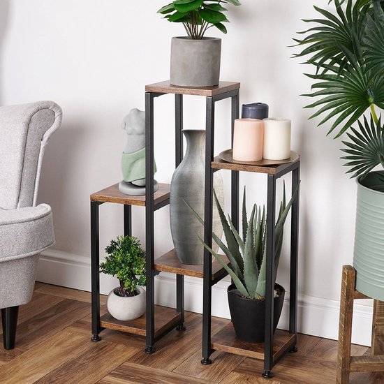 Plantenstandaard met bruine houten bladen en zwart metalen frame, met diverse planten, een beeldje en een vaas.