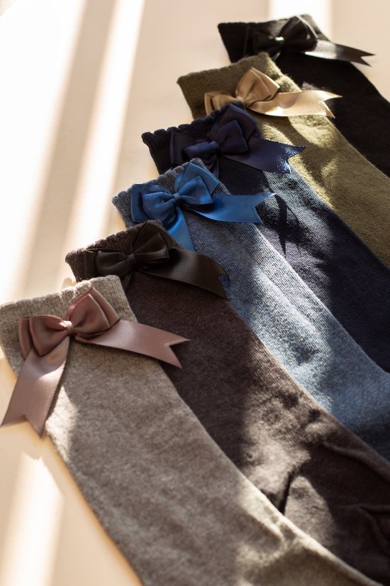 Rangée de chaussettes hautes dans différentes couleurs gris, marron, bleu foncé, vert et noir, chacune avec un nœud en satin.