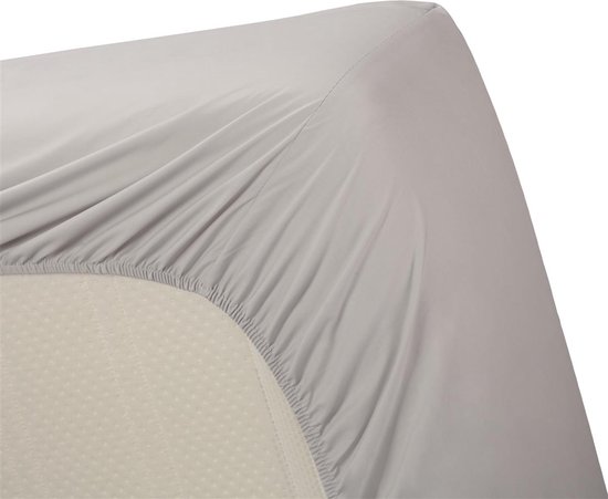 De hoek van een lichtgrijs hoeslaken op een matras.