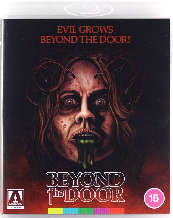 De cover van de horrorfilm 'Beyond the Door' met een angstige vrouw met draden in haar hoofd en groene smurrie die uit haar mond loopt.