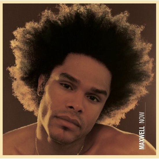 Close-up van Maxwell met grote afro-kapsel en "MAXWELL NOW" op de zijkant.