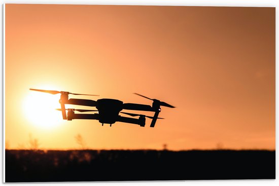 PVC Schuimplaat - Silhouet van Laagvliegende Drone bij Zonsondergang - 60x40 cm Foto op PVC Schuimplaat (Met Ophangsysteem)