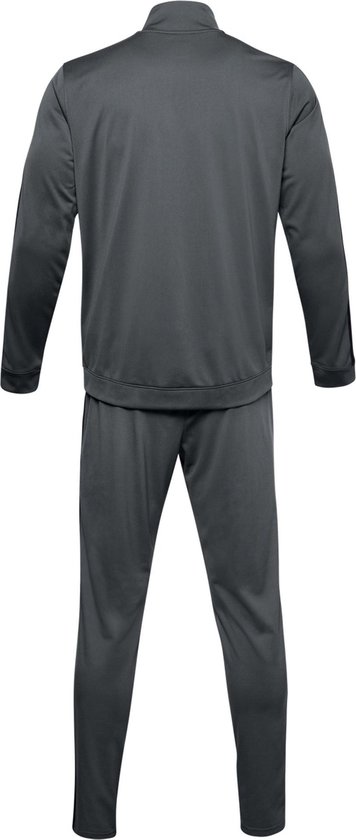 Achterkant van een grijs Under Armour trainingspak met zwarte strepen op de mouwen en zijkanten van de broek.