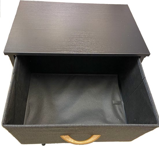 Bovenkant van een open lade van een zwart stoffen nachtkastje met houten handgreep.
