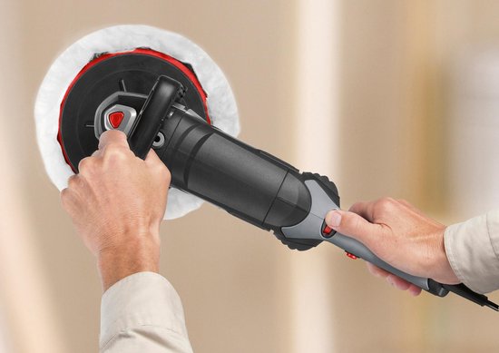 Handen gebruiken een Skil polijstmachine op een lichte muur.