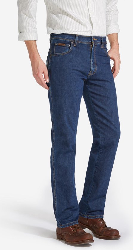 Blauwe Wrangler jeans, regular fit, gedragen met wit gestreept overhemd en bruine schoenen, zij-aanzicht.
