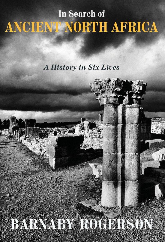 Boekomslag: In Search of Ancient North Africa door Barnaby Rogerson, met antieke zuilen onder een bewolkte lucht.