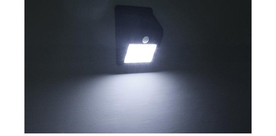 Zwarte solar wandlamp, verlicht de muur met een helder wit licht.