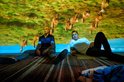 Twee mannen zitten op de grond, een projectie van kangoeroes op de achtergrond.