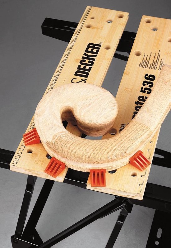 Houten gebogen stuk hout vastgeklemd op de Black & Decker Workmate 536 met oranje klemmen.