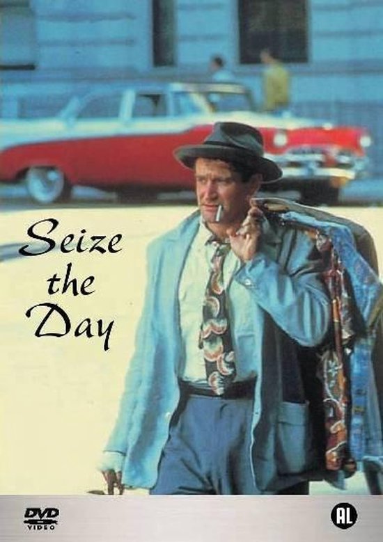 Een man met een hoed, lichtblauwe jas, das en sigaret draagt kleding over zijn schouder, met de tekst 'Seize the Day'.