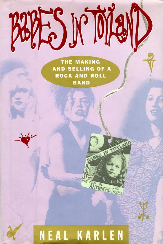 Couverture de livre avec le texte 'Babes in Toyland'. Trois femmes sont à l'arrière-plan, une tenant une étiquette avec la photo d'une jeune fille.