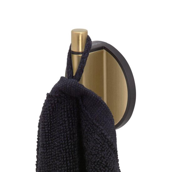 Une serviette noire est suspendue à un crochet doré avec une plaque arrière noire.