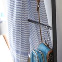 Detail van een blauw tasje dat aan een S-haak hangt aan de ladder.