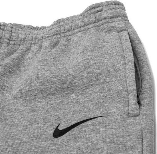 Grijze joggingbroek van Nike met zwarte swoosh en een zijzak.