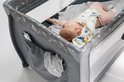 Close-up van een baby die in de grijze Lionelo Stefi Plus reiswieg met opbergzakjes ligt.
