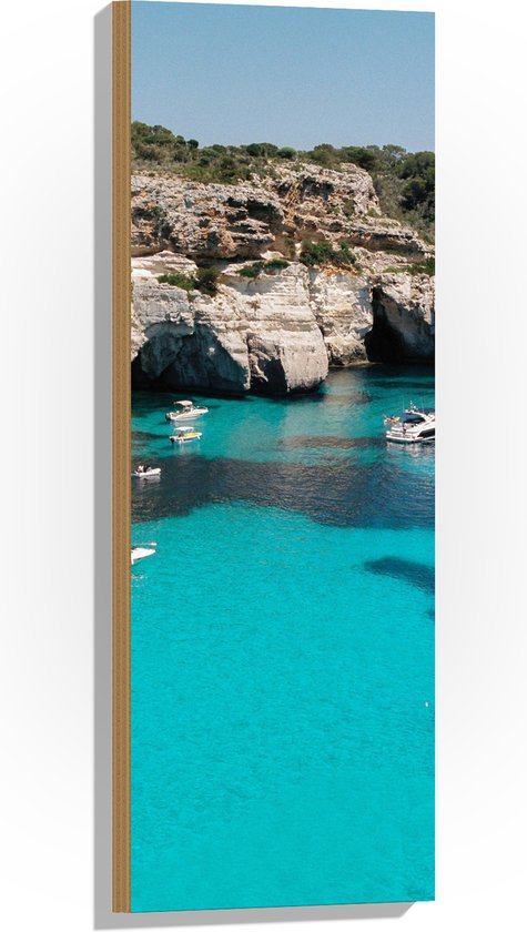 wallclassics-hout-kleine-bootjes-op-felblauw-water-voor-rotsen