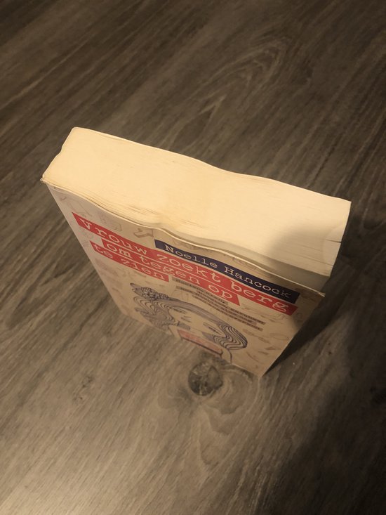 Gesloten boek op houten ondergrond, titel 'Vrouw zoekt berg om tegenop te zien'.