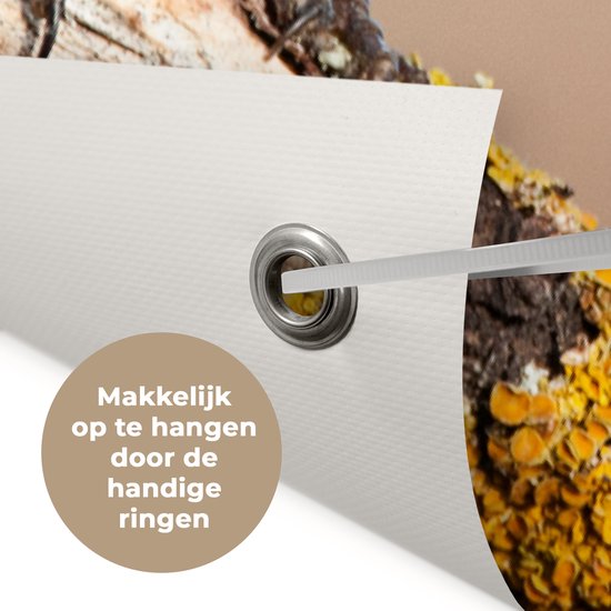 Close-up van de hoek van een tuinposter met roestvrijstalen ring en een tiewrap voor eenvoudige bevestiging.