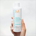 Hand die een fles Moroccanoil Hydrating Conditioner van 250 ml vasthoudt.