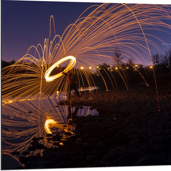 Dibond - Man met Lichtsnoer op Keien langs Rivier - 80x80 cm Foto op Aluminium (Wanddecoratie van metaal)