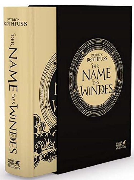 Luxe editie van 'Der Name des Windes' van Patrick Rothfuss in een zwarte beschermhoes met gouden details. De rug van het boek is beige met gouden letters.