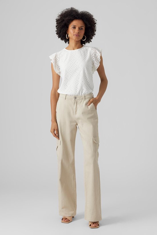 Femme portant un haut blanc court à volants et détails ajourés, et un pantalon cargo beige.