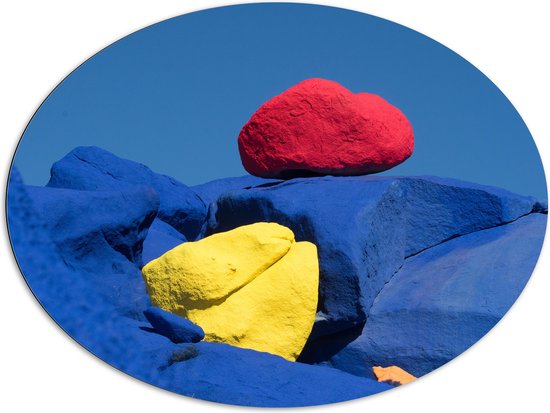 Dibond Ovaal - Rode en Gele Kei op Blauwe Keien - 108x81 cm Foto op Ovaal (Met Ophangsysteem)