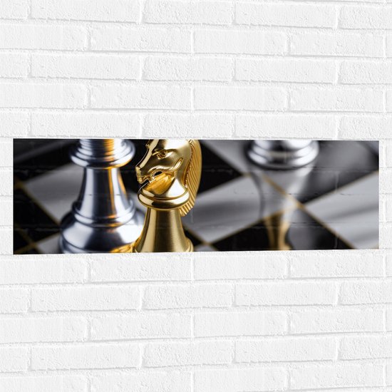 Muursticker - Foto van Drie Gouden en Zilveren Schaakstukken op Schaakbord - 90x30 cm Foto op Muursticker