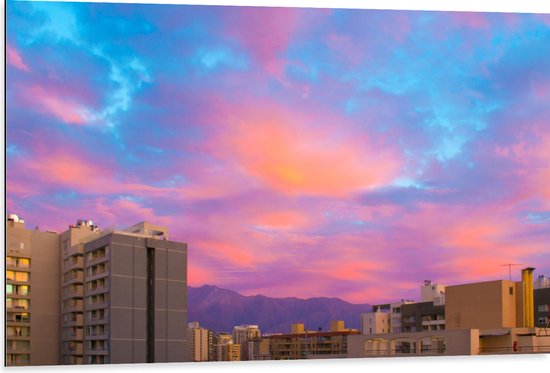 Dibond - Felkleurige Lucht boven Gebouwen in het Blauw met Roze en Paars - 105x70 cm Foto op Aluminium (Met Ophangsysteem)