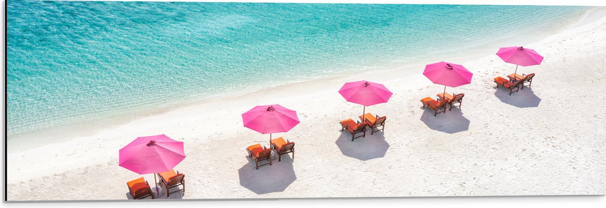 Dibond - Ligbedden onder Roze Parasols op het Witte Strand bij Blauwe Oceaan - 90x30 cm Foto op Aluminium (Wanddecoratie van metaal)