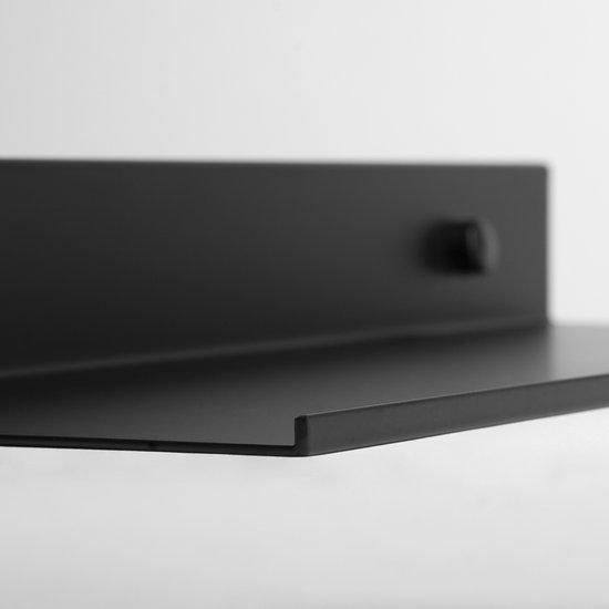 Close-up van een zwarte metalen wandplank met een opstaande rand en bevestigingsknop.