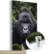 MuchoWow® Glasschilderij 80x120 cm - Schilderij acrylglas - Gorilla kijkt met zijn parelachtige ogen in de camera - Foto op glas - Schilderijen