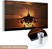 MuchoWow® Glasschilderij 80x40 cm - Schilderij acrylglas - Een silhouet van een straaljager tijdens een zonsondergang - Foto op glas - Schilderijen
