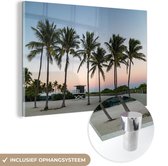 MuchoWow® Glasschilderij 90x60 cm - Schilderij acrylglas - De rij met palmbomen op een strand - Foto op glas - Schilderijen
