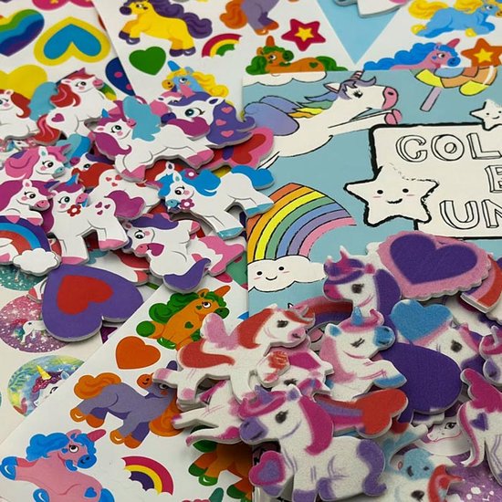Een close-up van een stapel eenhoorn stickers, deels foam, in verschillende kleuren en maten. Een kleurboek is zichtbaar.