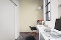 Lichte groene muur in een studeerkamer met bureau, computer en stoelen.
