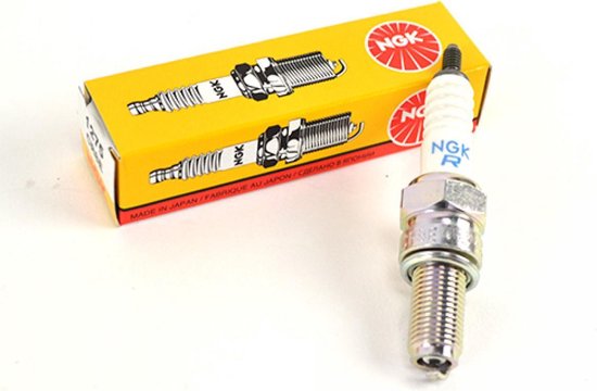 NGK bougie met witte keramische isolator, naast een geel NGK doosje.