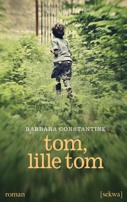 Un jeune garçon court loin de l'appareil photo à travers de l'herbe haute, avec le titre 'tom, lille tom'.