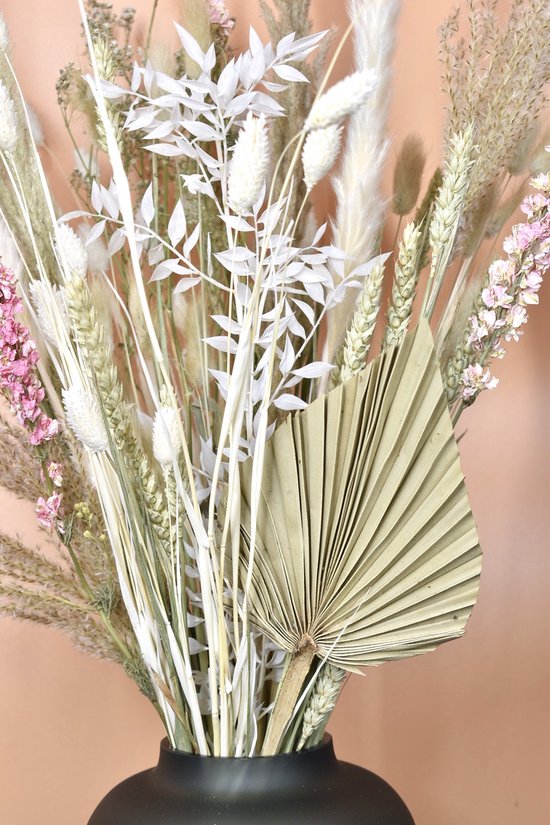 Bouquet de plantes et d'herbes séchées blanches, avec un éventail de palmier séché et des fleurs roses.